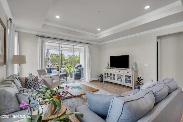 living room with hardwood / wood-style flooring, ornamental molding, and a tray ceiling