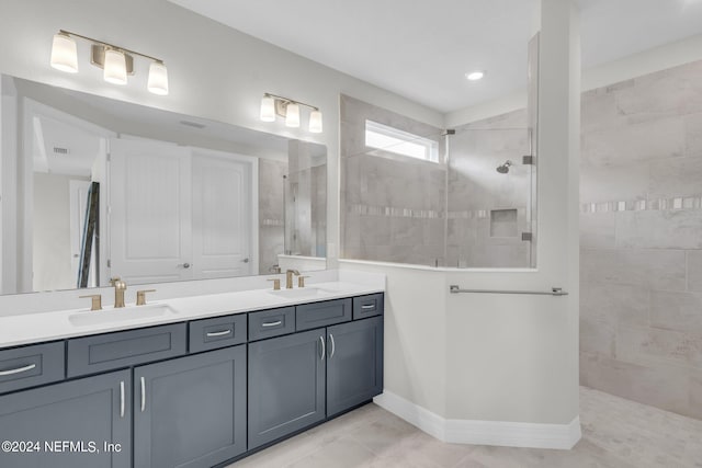 bathroom featuring vanity, tile patterned floors, and tiled shower