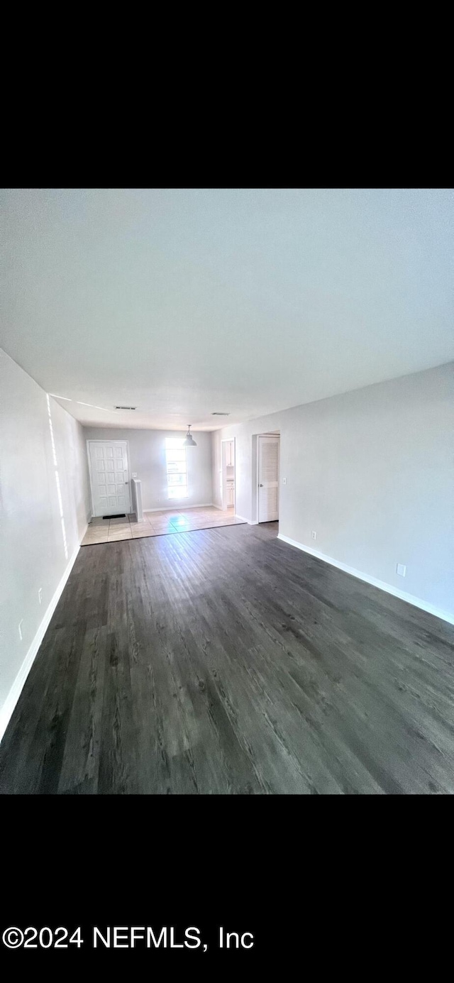 unfurnished living room with baseboards and wood finished floors