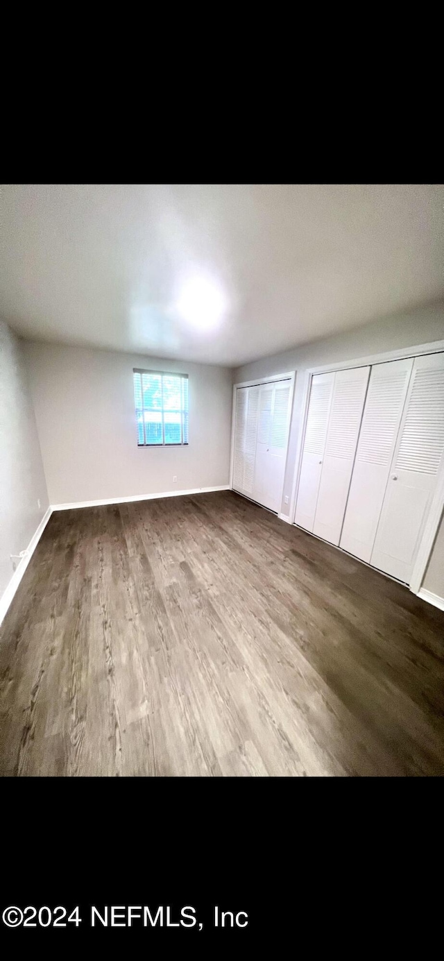 unfurnished bedroom featuring wood finished floors and baseboards
