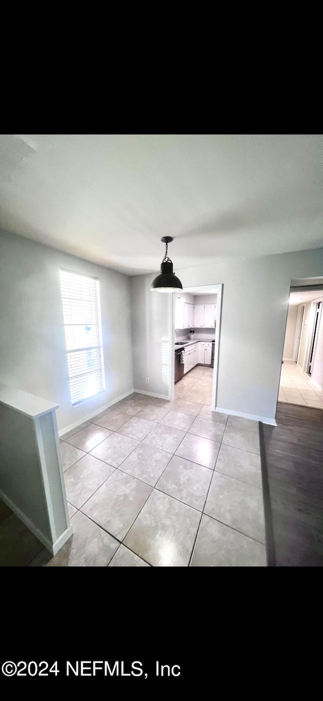 interior space featuring light tile patterned flooring and baseboards