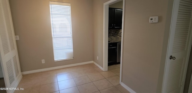 hall with light tile patterned floors, plenty of natural light, and baseboards