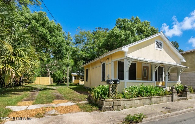 view of side of property featuring covered porch