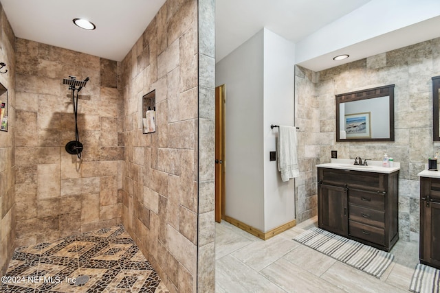 bathroom with vanity, tile walls, and tiled shower