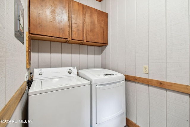 laundry room with separate washer and dryer and cabinets