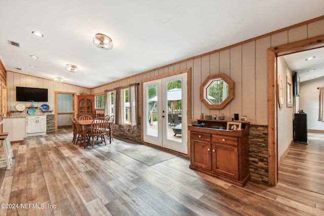 dining area with wood-type flooring, vaulted ceiling, and french doors