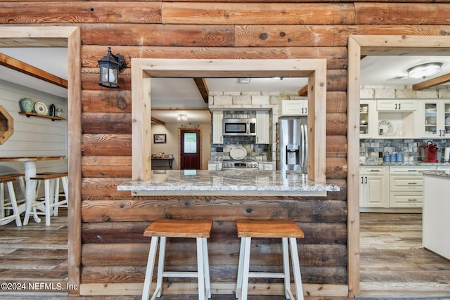 kitchen featuring stainless steel appliances, light stone countertops, and decorative backsplash