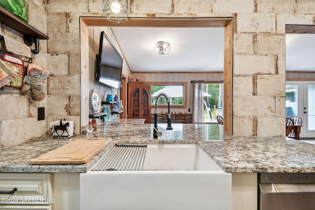 kitchen featuring light stone countertops, sink, cream cabinetry, and french doors