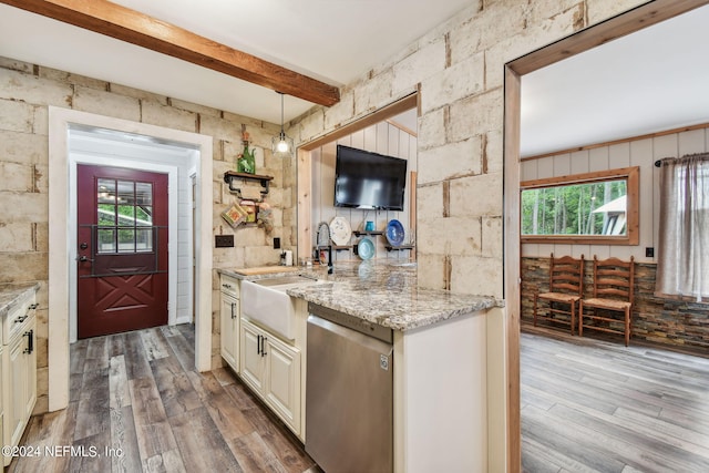 kitchen with stainless steel dishwasher, light stone counters, beam ceiling, and light hardwood / wood-style flooring