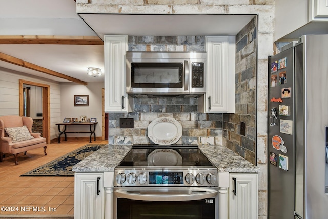 kitchen featuring stainless steel appliances, white cabinetry, backsplash, and light stone counters