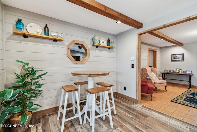 dining space featuring wood-type flooring and beam ceiling