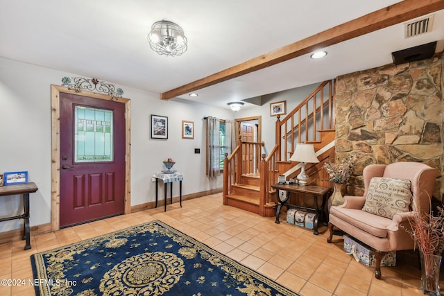 entrance foyer with beamed ceiling and light tile patterned floors