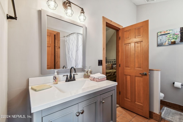 bathroom featuring vanity, toilet, and tile patterned flooring