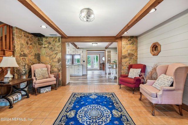 sitting room featuring beam ceiling and tile patterned flooring