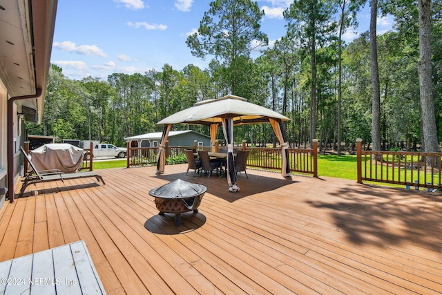 wooden deck with a gazebo, an outdoor fire pit, and a yard