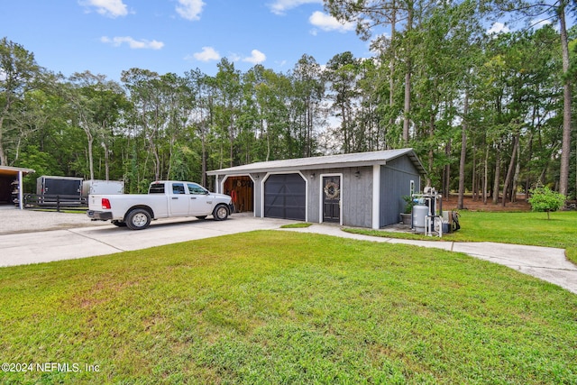 view of front of property with a garage, an outdoor structure, and a front yard