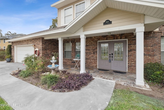 doorway to property with a garage and french doors