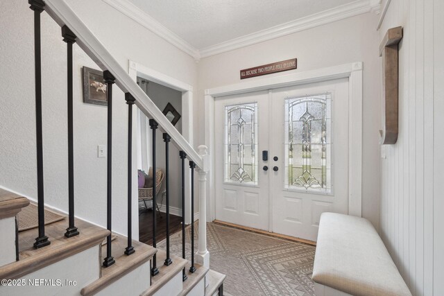 foyer entrance featuring french doors and crown molding