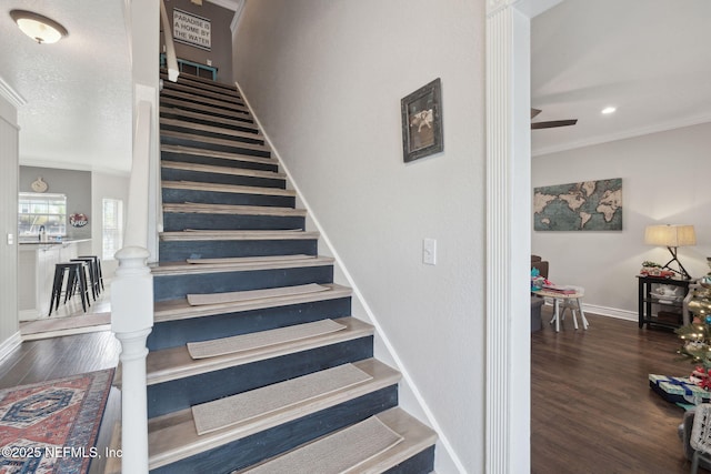 staircase with crown molding and hardwood / wood-style floors