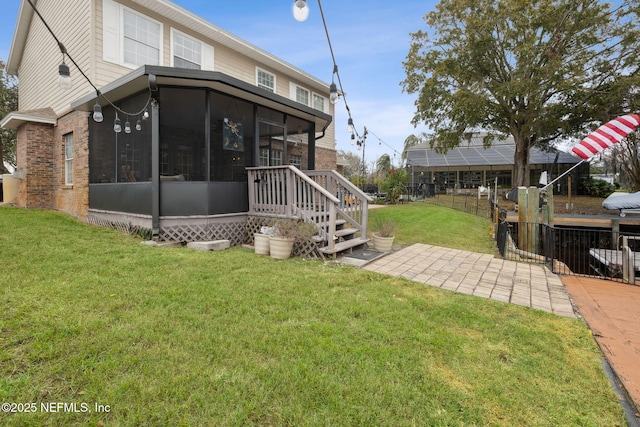 rear view of house with a lawn and a sunroom