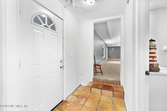 corridor featuring light tile patterned floors and a textured ceiling