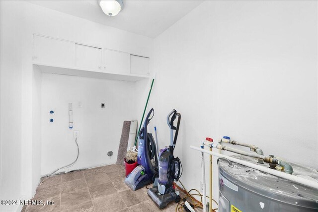 misc room with water heater and light tile patterned floors