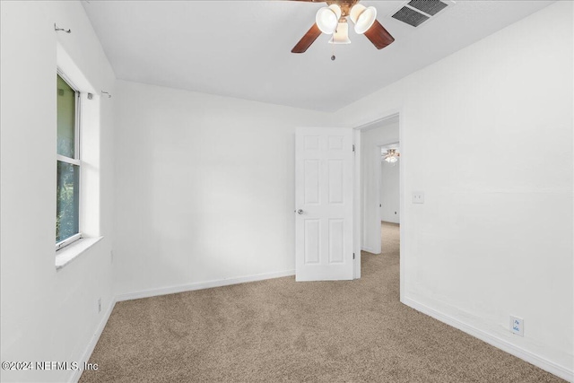 carpeted spare room featuring ceiling fan