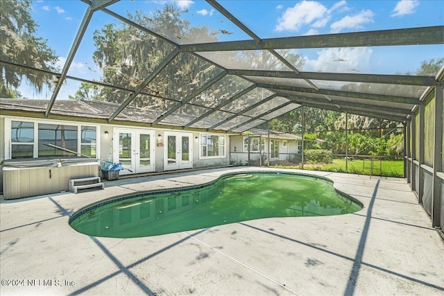 view of pool featuring a hot tub, a lanai, a patio, and french doors