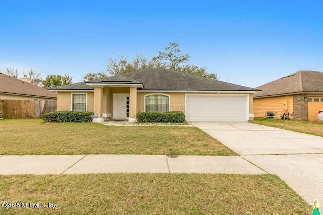 view of front of house with a garage, concrete driveway, stucco siding, fence, and a front yard