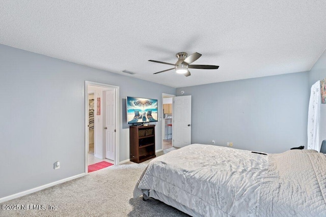 carpeted bedroom with visible vents, ceiling fan, a textured ceiling, and baseboards