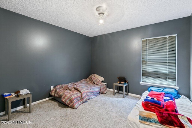 carpeted bedroom with a textured ceiling, a ceiling fan, and baseboards