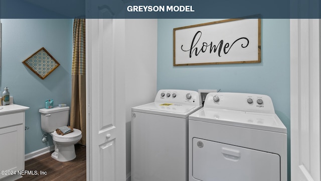 clothes washing area with washer and dryer and dark wood-type flooring