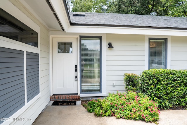 property entrance with roof with shingles