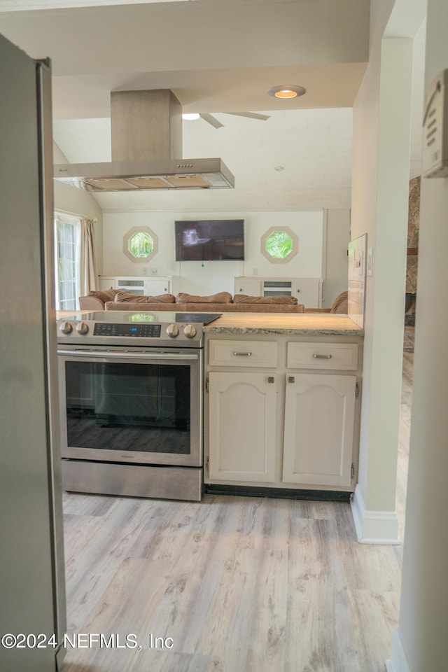 kitchen featuring light countertops, appliances with stainless steel finishes, open floor plan, ventilation hood, and light wood-type flooring