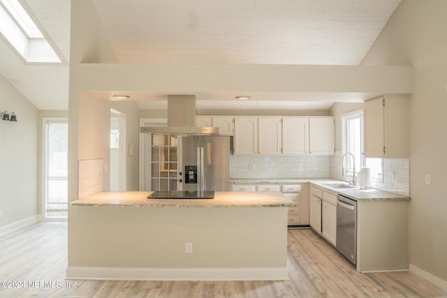 kitchen featuring stainless steel appliances, a sink, island exhaust hood, and tasteful backsplash