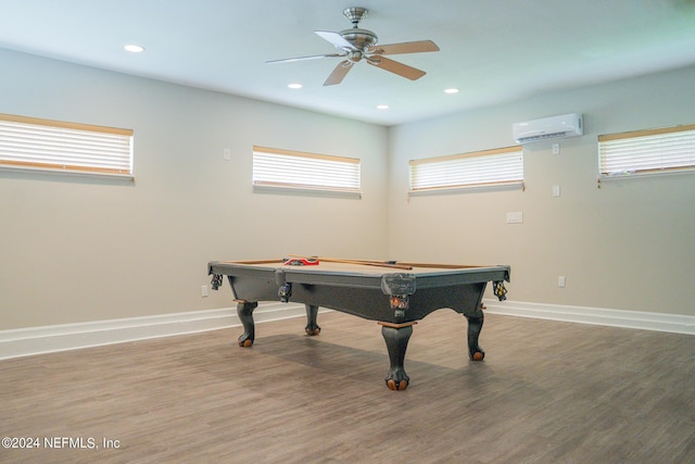 rec room featuring an AC wall unit, a healthy amount of sunlight, and wood finished floors