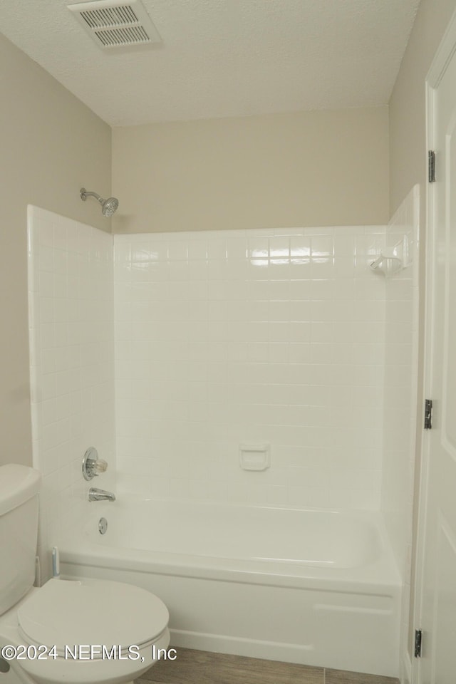 bathroom featuring toilet, visible vents, and  shower combination