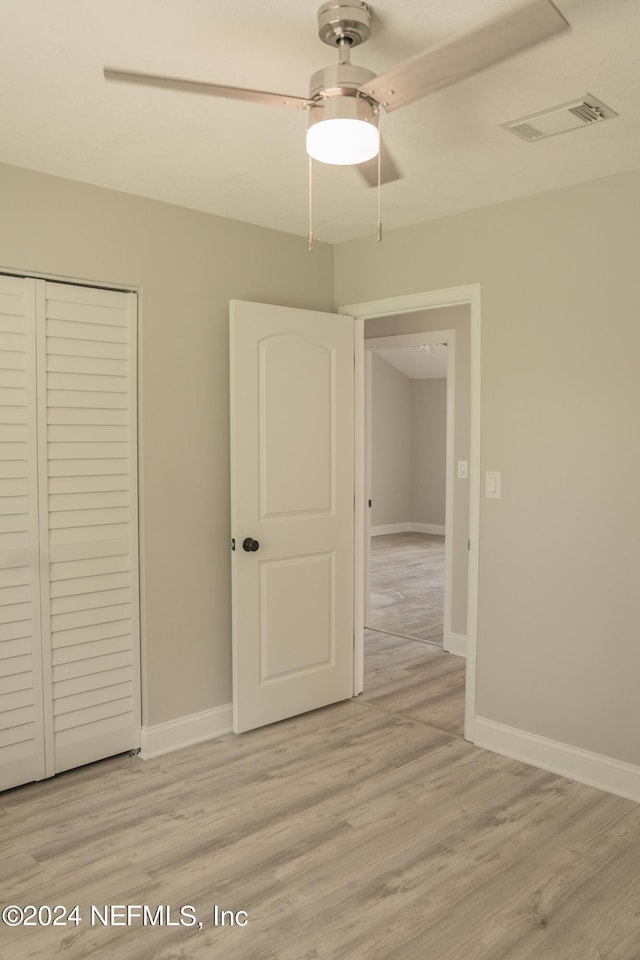 unfurnished bedroom with light wood finished floors, a closet, visible vents, and baseboards