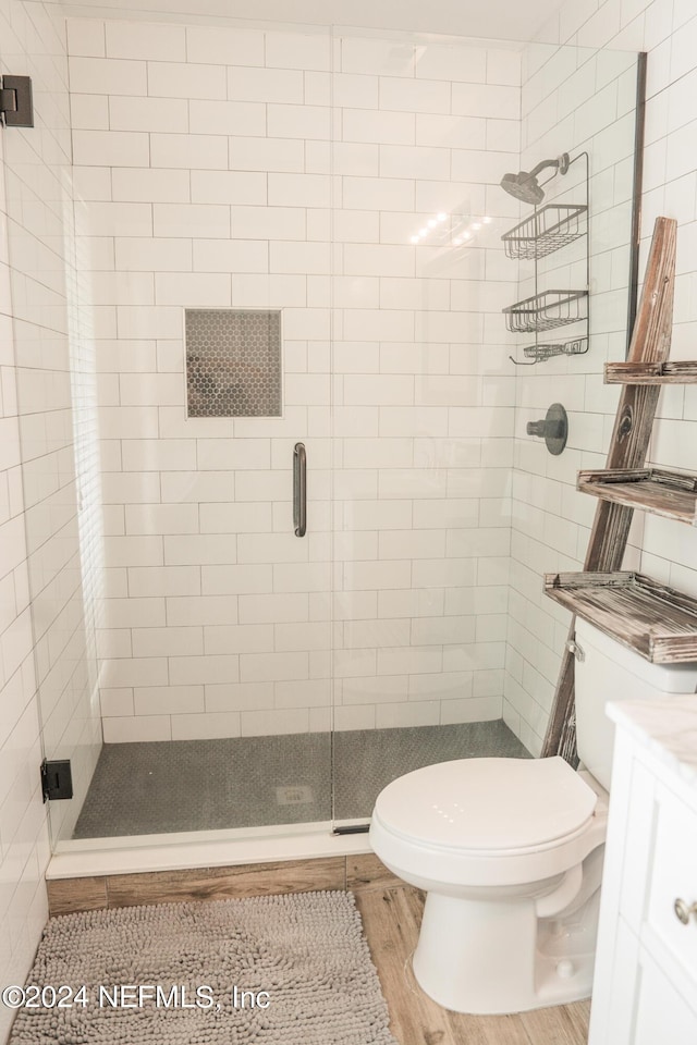 full bathroom featuring vanity, a shower stall, toilet, and wood finished floors