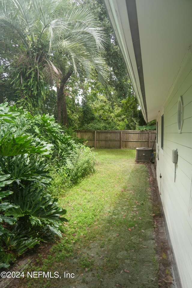 view of yard with fence and cooling unit