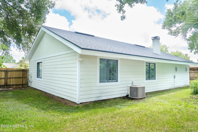 back of house with a yard, central AC unit, a chimney, and fence