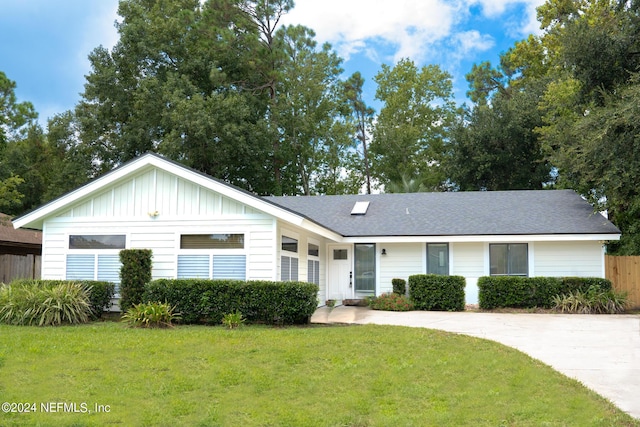 single story home with fence, board and batten siding, and a front yard