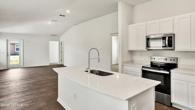 kitchen with lofted ceiling, sink, white cabinetry, stainless steel appliances, and a kitchen island with sink