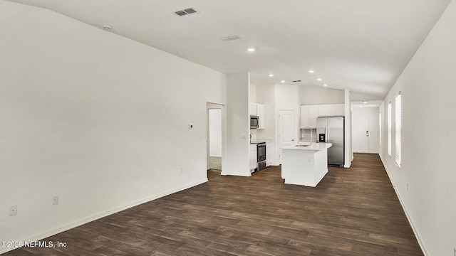 kitchen featuring white cabinetry, lofted ceiling, a kitchen island, appliances with stainless steel finishes, and dark hardwood / wood-style floors