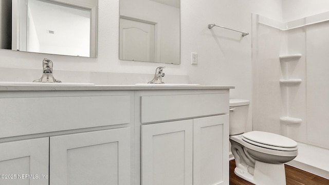 bathroom featuring hardwood / wood-style flooring, vanity, toilet, and walk in shower