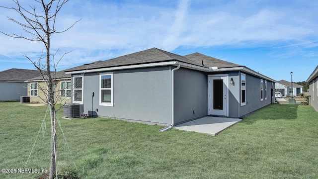 rear view of house featuring central AC unit, a lawn, and a patio area