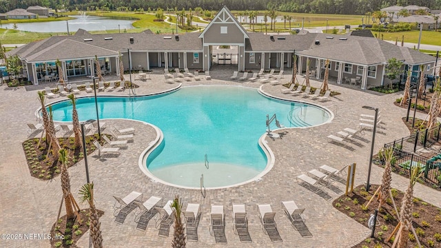 view of pool featuring a patio and a water view