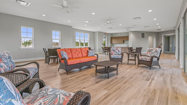 living room featuring ceiling fan and light hardwood / wood-style floors