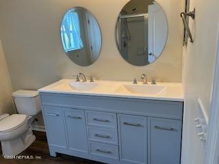 bathroom featuring hardwood / wood-style floors, vanity, an enclosed shower, and toilet