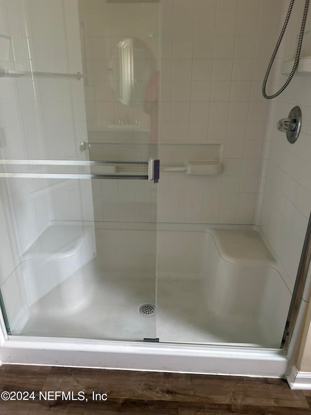 bathroom featuring hardwood / wood-style flooring and a shower with door